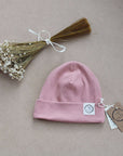 Kuschelig weiche Beanie aus GOTS-zertifizierter Bio-Baumwolle in unserer exklusiven Farbe Dusty Rose.  Die Beanie ist aus fein geripptem und sehr elastischem Stoff, sodass die Mütze mit wächst und Ihr lange Freude daran haben werdet.  Kreiere perfekte Looks indem Du die Beanie mit unseren Schühchen, Leggings und Schals kombinierst!