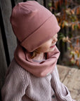 Kuschelig weiche Beanie aus GOTS-zertifizierter Bio-Baumwolle in unserer exklusiven Farbe Dusty Rose.  Die Beanie ist aus fein geripptem und sehr elastischem Stoff, sodass die Mütze mit wächst und Ihr lange Freude daran haben werdet.  Kreiere perfekte Looks indem Du die Beanie mit unseren Schühchen, Leggings und Schals kombinierst!